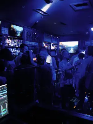La grande salle pleine de monde sous les lumières bleues, les écrans au fond