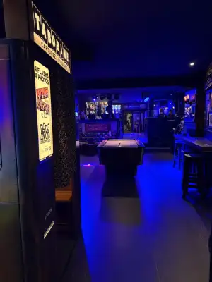 Le coin billard éclairé en bleu, sa table au fond de la salle
